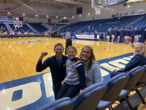 George and his family sitting courtside at a UCSD basketball game