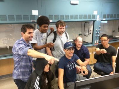Dr. Marco Curreli working with students in the lab