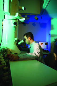 Professor Dayeh looking into a microscope in his lab