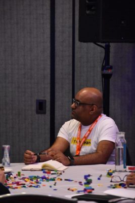 Nishal Mohan seated at a desk collaborating with colleagues