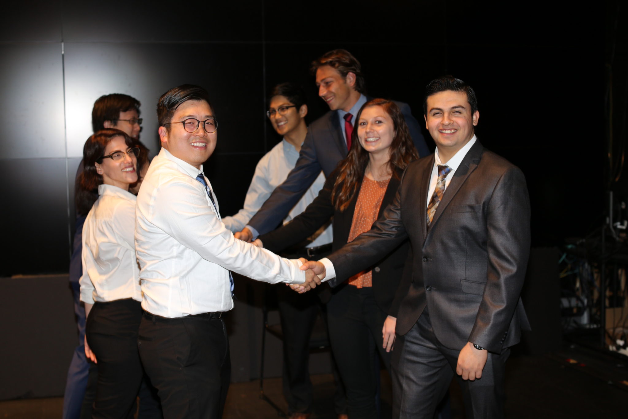 i4NS program members shaking hands at an event